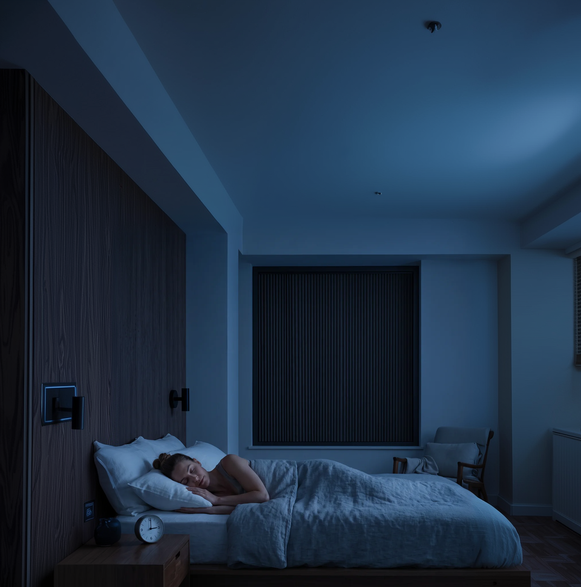 A dark bedroom with a OneRest blackout blind fitted to the window